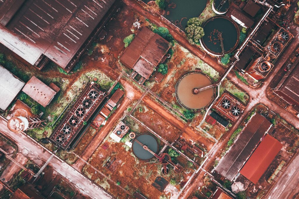 Drone view of contemporary industrial city district with manufacture constructions and factory warehouses